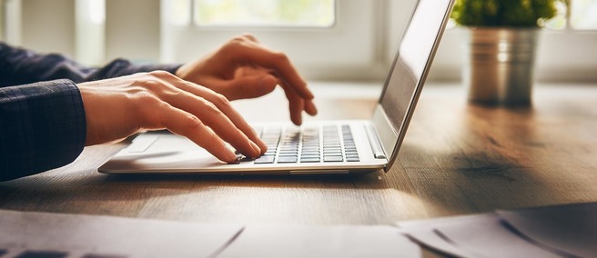Finger tippen auf Tastatur eines Laptops